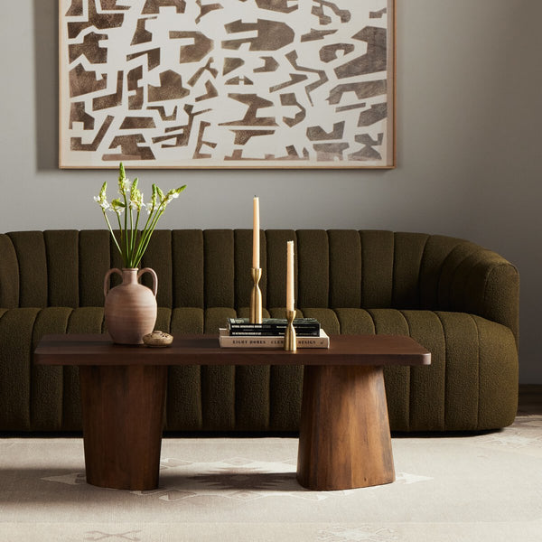 Living room with a brown sofa, wooden coffee table, and abstract wall art.