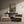 Modern living room with beige armchairs, a console table with decor items, and a wall painting.